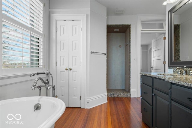 bathroom featuring a washtub, vanity, and wood-type flooring