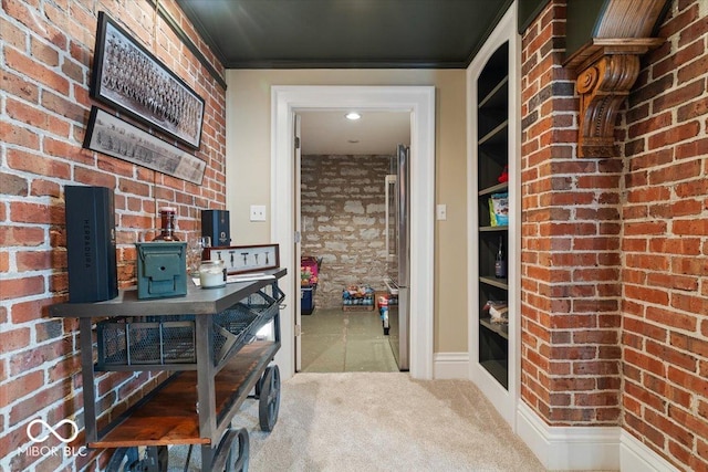 interior space with brick wall, carpet floors, and crown molding