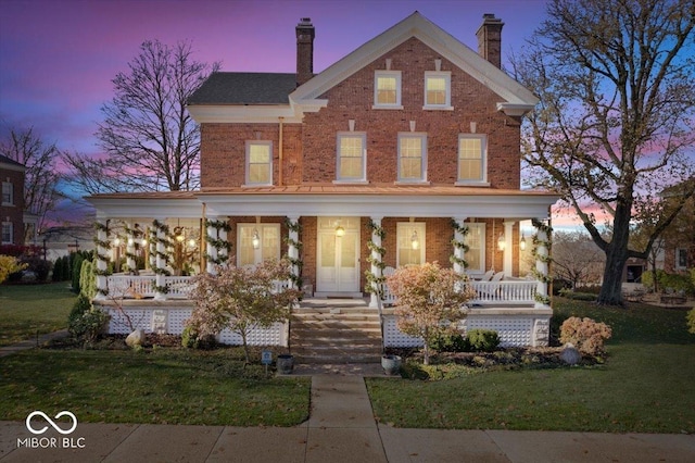 view of front of house featuring a porch and a yard