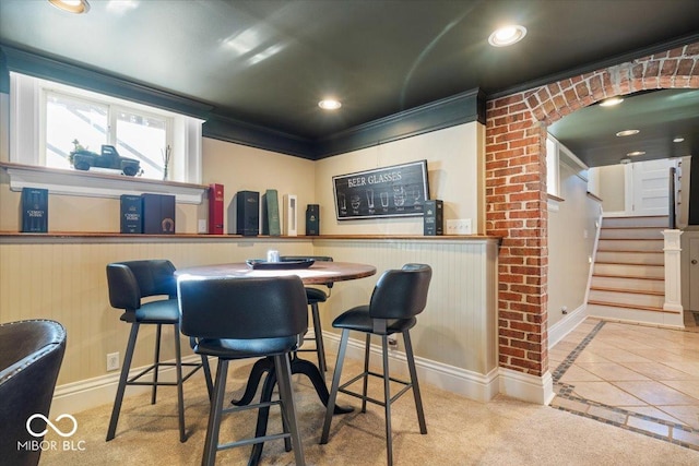 bar featuring tile patterned flooring and crown molding