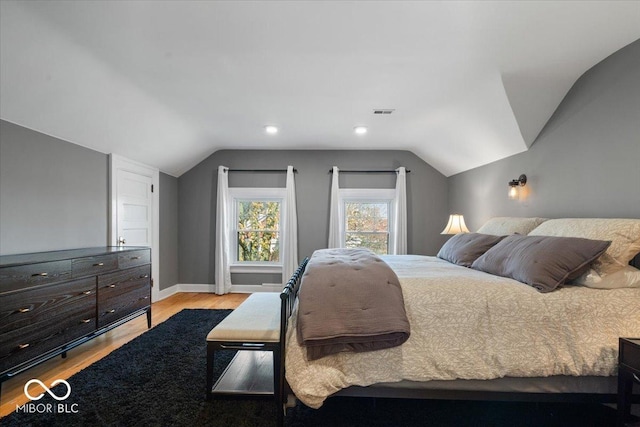 bedroom with vaulted ceiling and light hardwood / wood-style floors