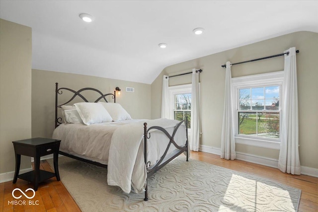 bedroom with light wood-type flooring and vaulted ceiling