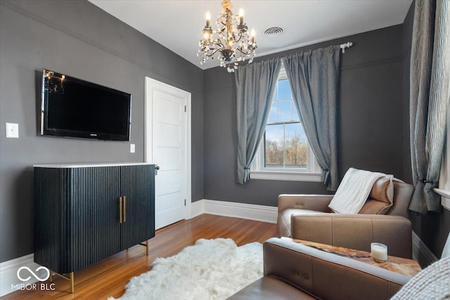 sitting room with an inviting chandelier and wood-type flooring