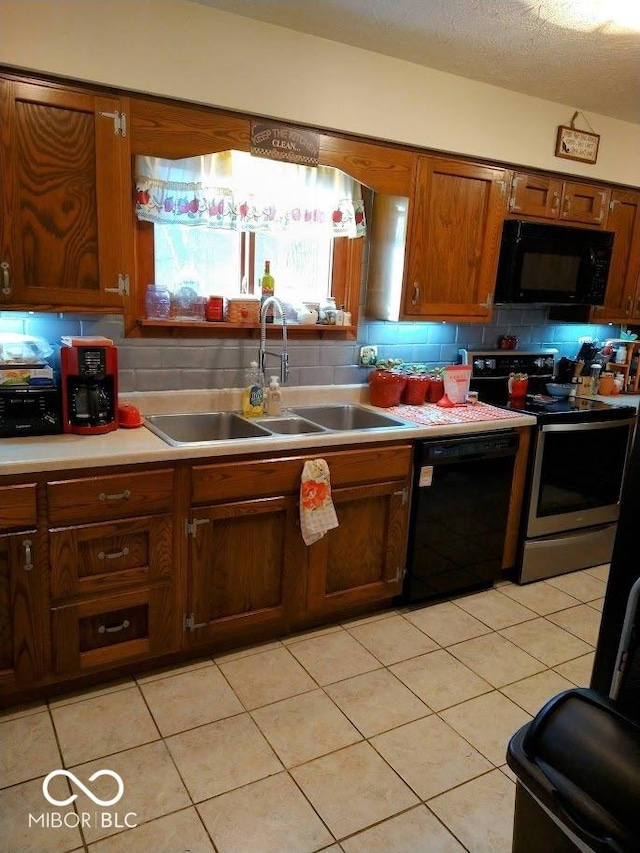 kitchen with sink, backsplash, a textured ceiling, light tile patterned floors, and black appliances