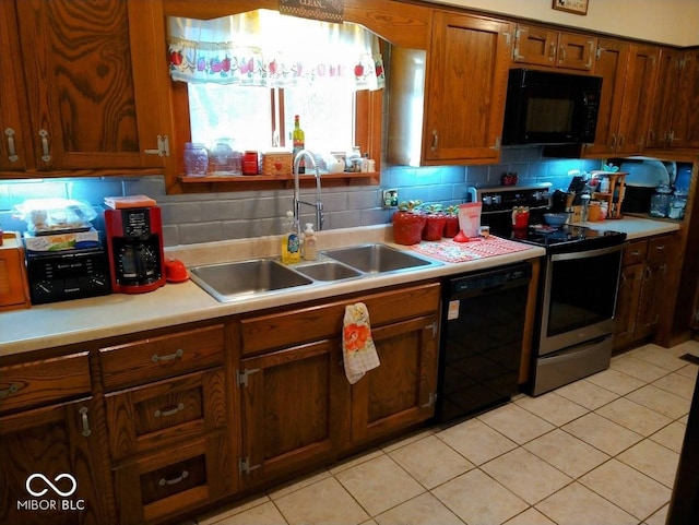 kitchen with light tile patterned floors, sink, tasteful backsplash, and black appliances