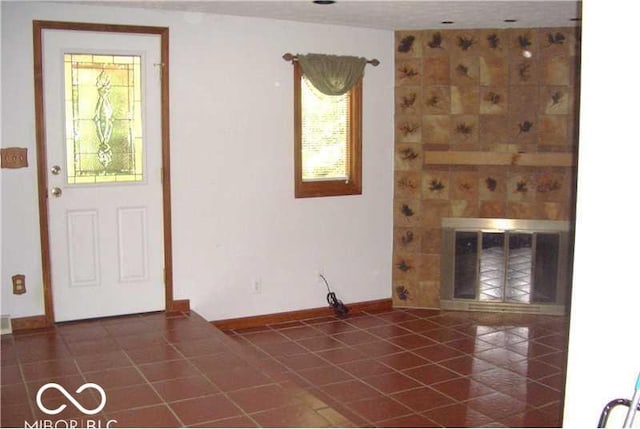 entrance foyer featuring dark tile patterned floors and a tiled fireplace