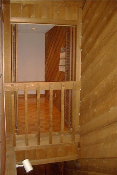 staircase featuring wood walls