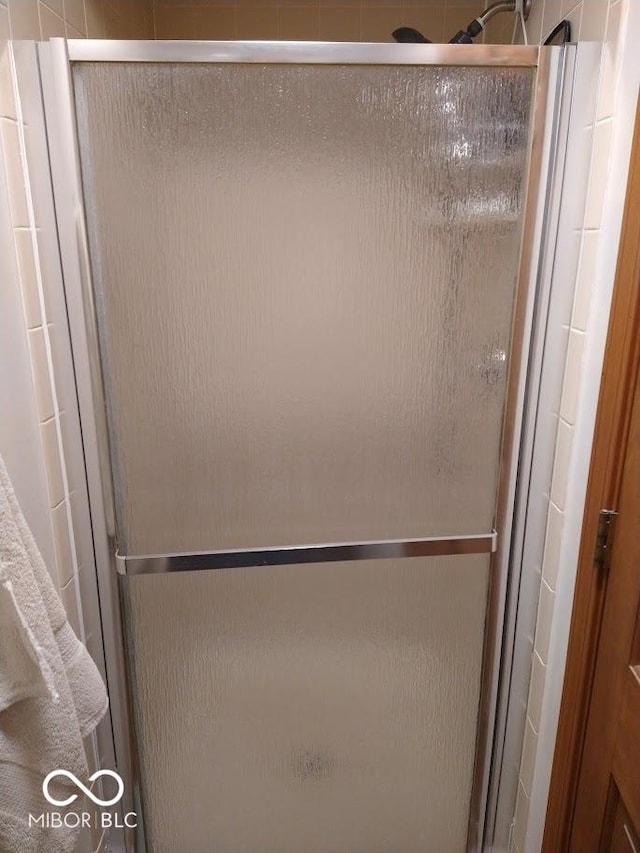 bathroom with a shower with door