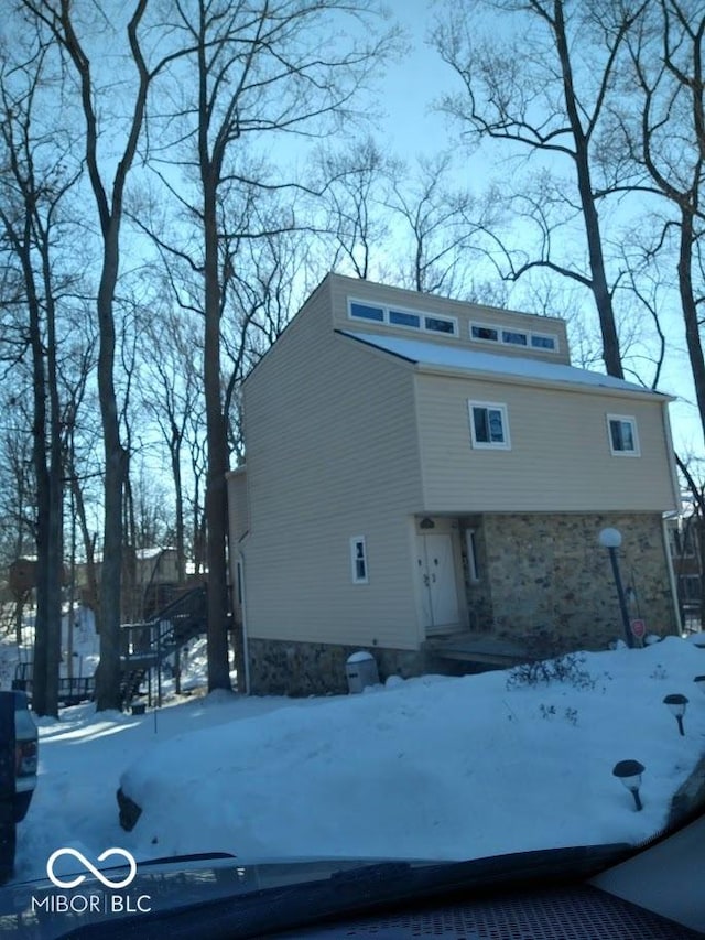 view of snow covered back of property