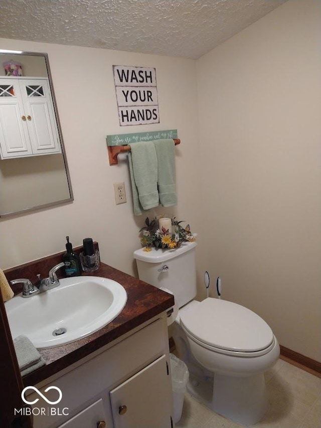 bathroom featuring vanity, a textured ceiling, and toilet