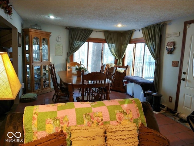 tiled dining area featuring a textured ceiling