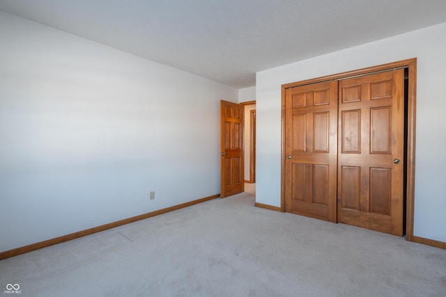 unfurnished bedroom with a closet and light carpet