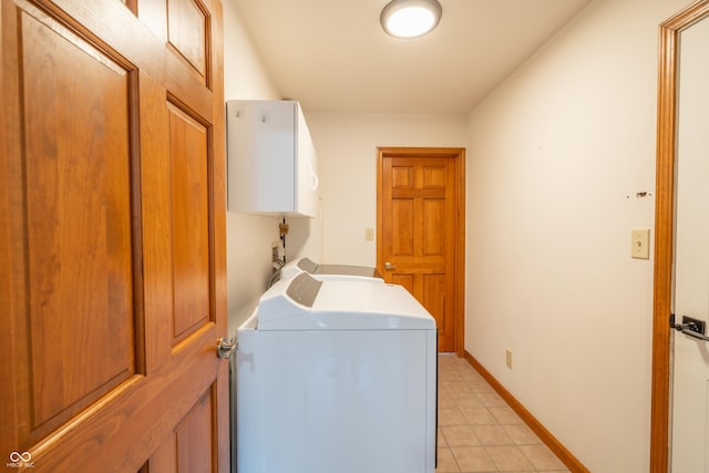 laundry room with washer and dryer, cabinets, and light tile patterned floors