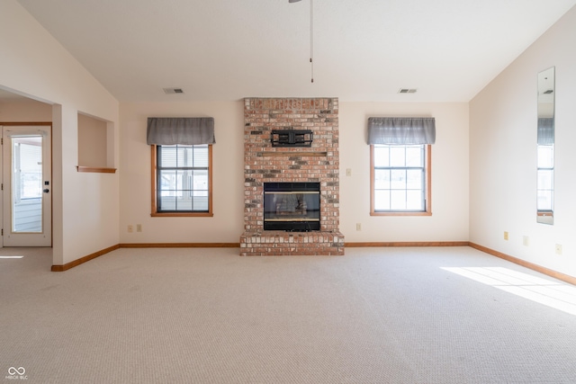 unfurnished living room with light colored carpet, vaulted ceiling, and a fireplace