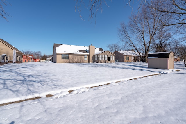 snowy yard featuring a storage unit