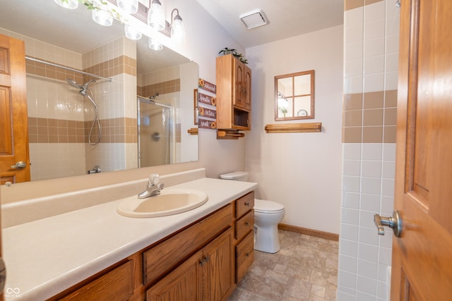 bathroom featuring toilet, a tile shower, and vanity