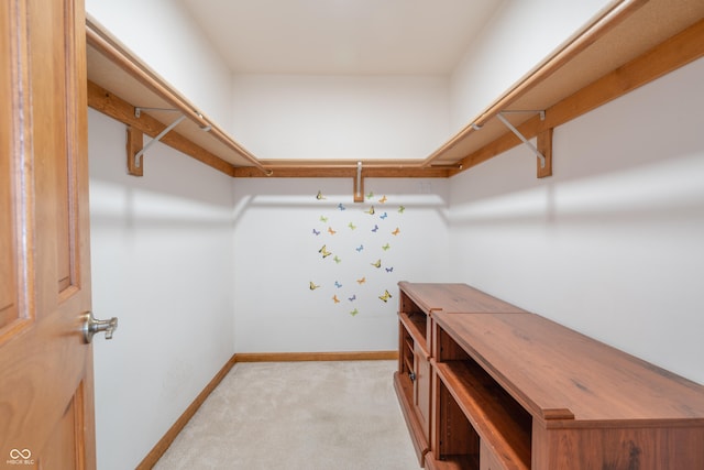 walk in closet featuring light carpet