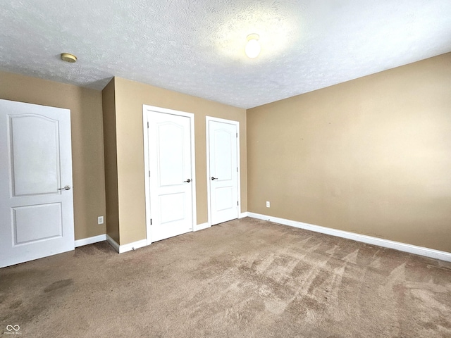 unfurnished bedroom with a textured ceiling and carpet flooring