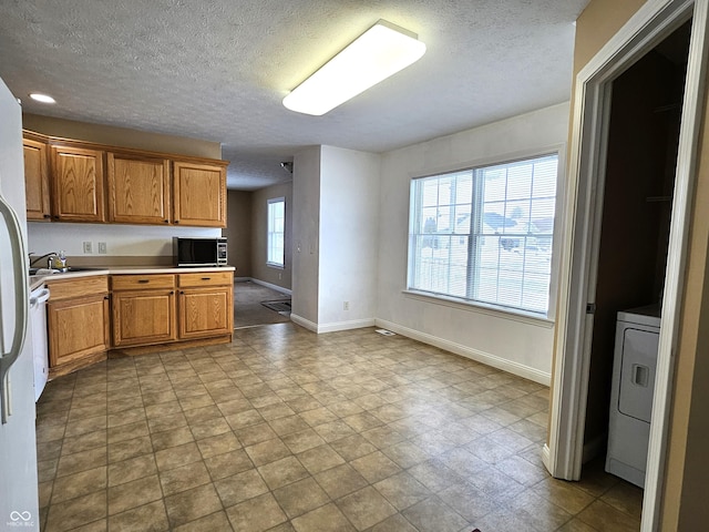 kitchen featuring sink, washer / dryer, and a textured ceiling