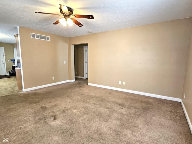 spare room featuring carpet flooring, a textured ceiling, and ceiling fan