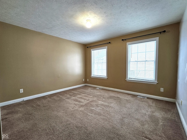 carpeted empty room with a textured ceiling