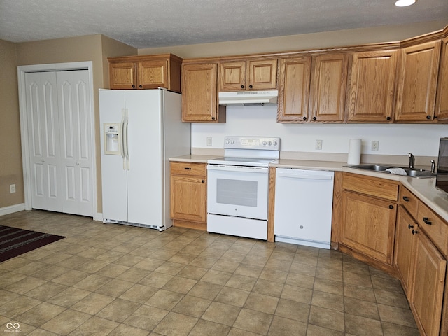 kitchen with sink, white appliances, and a textured ceiling