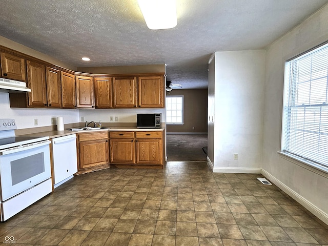 kitchen with white appliances, a textured ceiling, ceiling fan, and sink