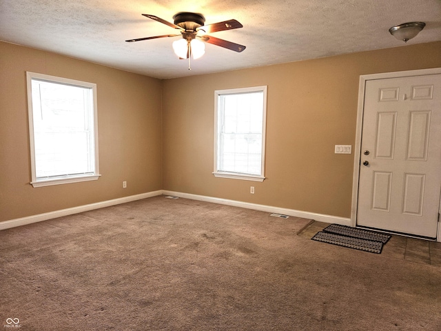 foyer entrance featuring carpet flooring, ceiling fan, and plenty of natural light