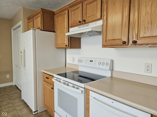 kitchen with white appliances, a textured ceiling, and light tile patterned floors