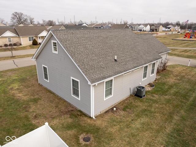 view of side of home featuring a lawn and central air condition unit