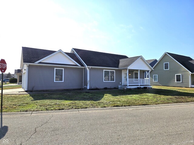 single story home with a garage, covered porch, and a front lawn