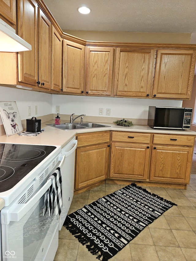 kitchen featuring light tile patterned flooring, white appliances, and sink