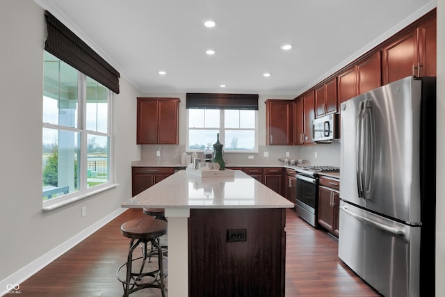 kitchen featuring appliances with stainless steel finishes, plenty of natural light, a kitchen island, and decorative backsplash