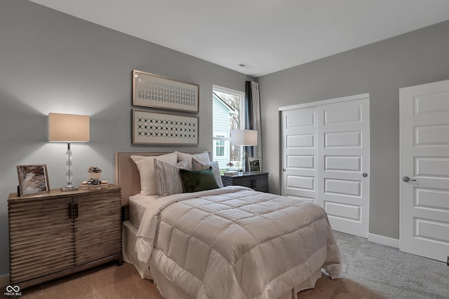 carpeted bedroom with baseboards, visible vents, and a closet