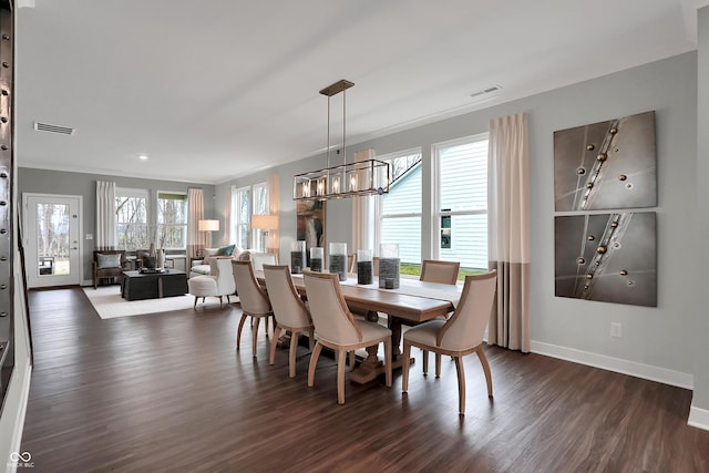 dining space with dark wood-style floors, visible vents, baseboards, and an inviting chandelier