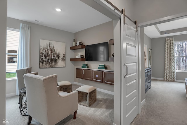 living room featuring a barn door, recessed lighting, light colored carpet, visible vents, and baseboards