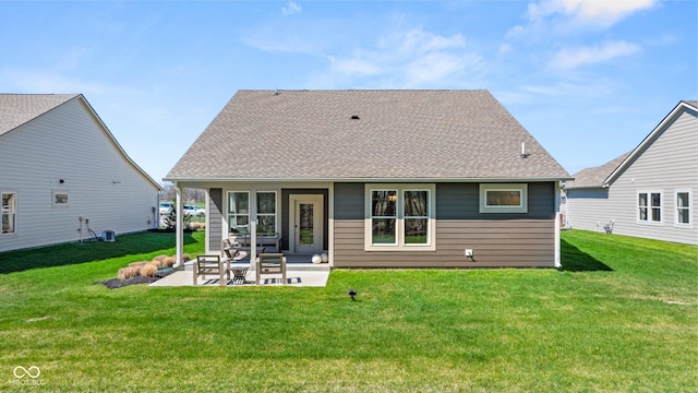 back of property with a yard, a shingled roof, and a patio