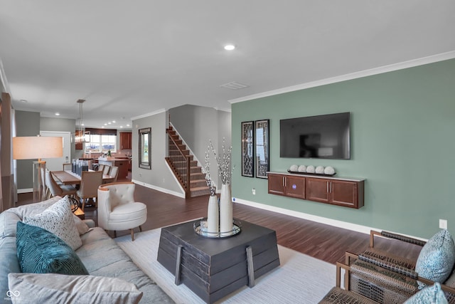 living room featuring recessed lighting, dark wood-type flooring, ornamental molding, baseboards, and stairs