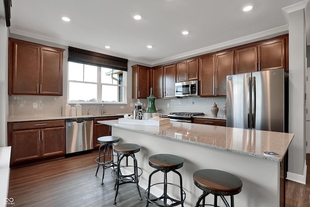 kitchen with backsplash, dark wood finished floors, stainless steel appliances, and a sink