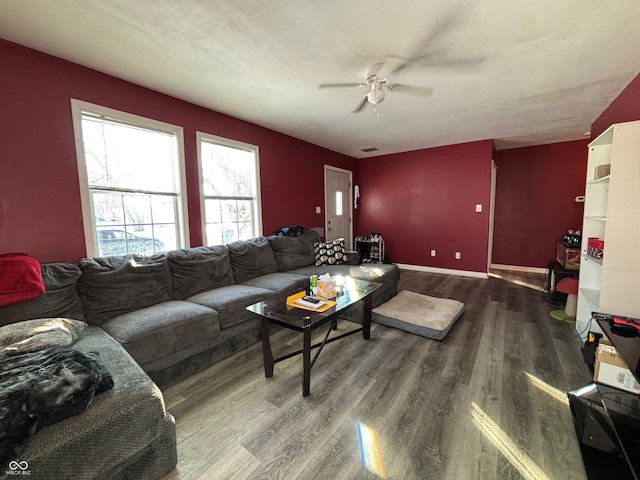 living room featuring ceiling fan, a textured ceiling, and wood-type flooring