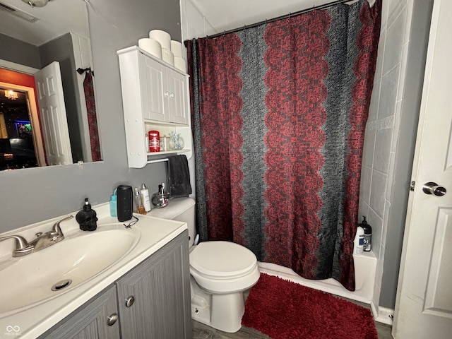 full bathroom featuring toilet, shower / tub combo with curtain, and vanity