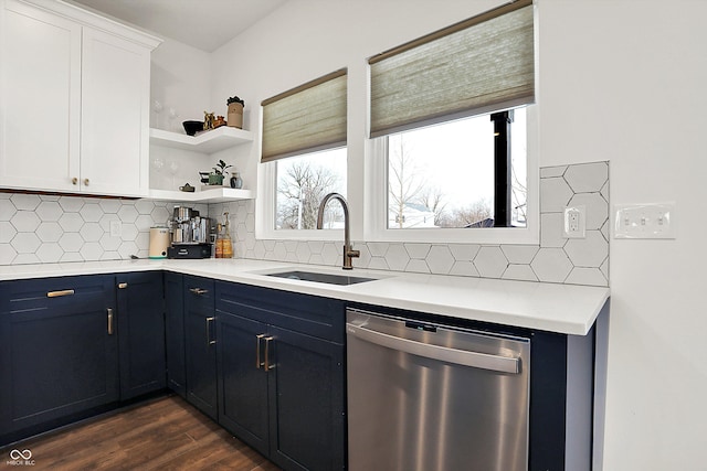 kitchen with stainless steel dishwasher, white cabinetry, backsplash, and sink