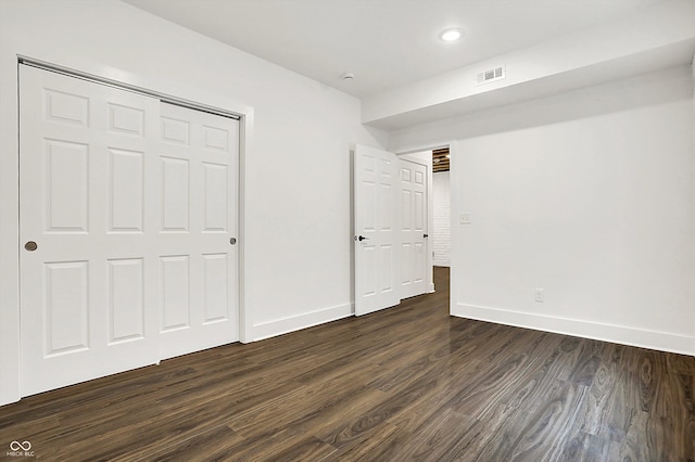 unfurnished bedroom with a closet and dark hardwood / wood-style floors