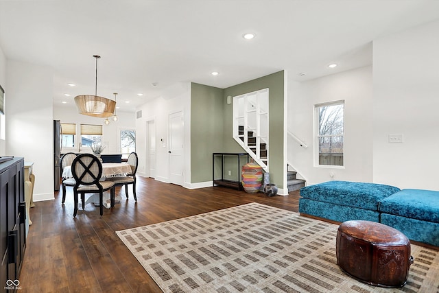 living room with dark wood-type flooring and a healthy amount of sunlight