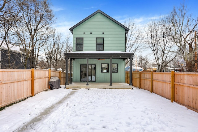 snow covered rear of property featuring a porch