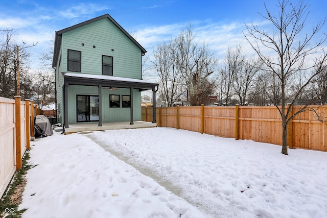 view of snow covered back of property