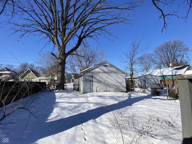 yard layered in snow with an outbuilding and a garage