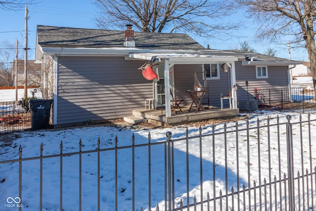 snow covered property with covered porch