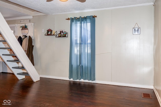 spare room featuring a textured ceiling, ceiling fan, ornamental molding, and dark hardwood / wood-style flooring