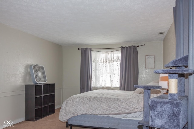 bedroom with a textured ceiling and carpet flooring